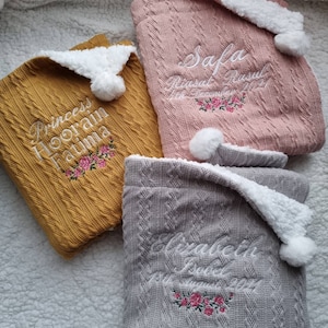 Personalised baby blanket with name, birth date and beautiful floral motif. Pom Pom feature and Sherpa Fleece backing. Soft cable knit.