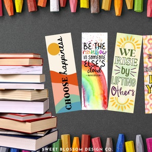 May include: Four colorful bookmarks with inspirational quotes. The first bookmark is a colorful abstract design with the text "Choose happiness". The second bookmark features a rainbow watercolor design with the quote "Be the rainbow in someone else's cloud - Maya Angelou". The third bookmark has a yellow background with a sun and the text "We rise by lifting others". The fourth bookmark has a geometric pattern with the text "Be bold, be bright, be you".
