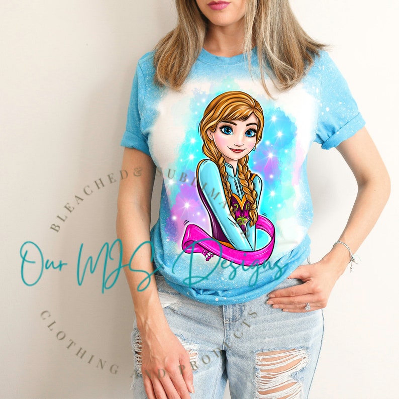 May include: A blue t-shirt with a tie-dye effect featuring a cartoon image of Anna from Frozen. The image is surrounded by a pink, purple, and blue watercolour background with glitter accents. The text "Our MDS Designs" is visible in the bottom left corner of the image.