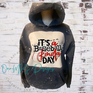 Puede incluir: Sudadera con capucha negra con un gr&aacute;fico de b&eacute;isbol blanco y negro. El gr&aacute;fico dice "It's a Baseball Kinda Day".