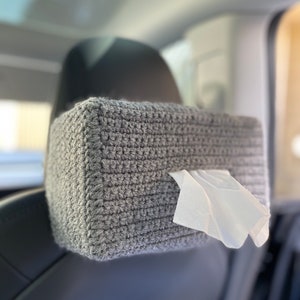 May include: Gray crocheted tissue box holder hanging on the back of a car seat.