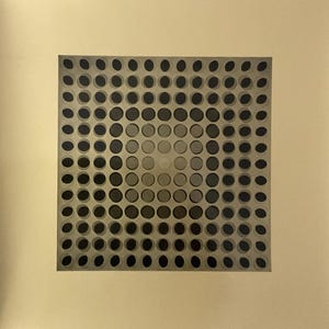 Peut inclure: Une grille carrée de cercles noirs sur un fond beige. Les cercles sont disposés selon un motif qui crée une impression de profondeur et de perspective.