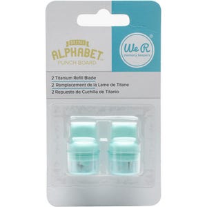 May include: A package containing two light blue titanium refill blades for a mini alphabet punch board. The package has the "We R Memory Keepers" logo and text in English, French, and Spanish.