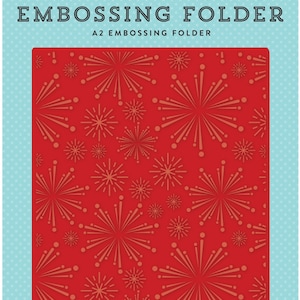 May include: Red A2 embossing folder with a repeating pattern of stylized starbursts in shades of gold. The folder is labeled "EMBOSSING FOLDER" and "A2 EMBOSSING FOLDER". The background is light blue with white polka dots. The top left corner has the text "WISH UPON A STAR".