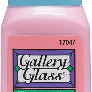 K&ouml;nnte beinhalten: Eine rosa Flasche Gallery Glass Window Color Farbe. Die Flasche ist mit dem Produktnamen und Anweisungen zum Erstellen eines Glasmalereieffekts beschriftet. Die Flasche enth&auml;lt 59 ml Farbe.