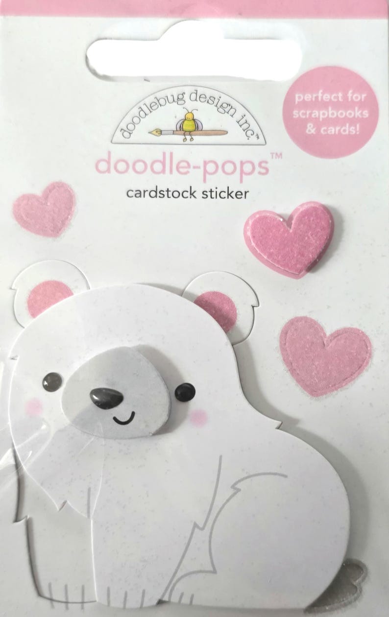 May include: A cardstock sticker set featuring a white polar bear and pink hearts. The sticker set includes the text "doodle-pops" and "cardstock sticker". The packaging also includes the text "perfect for scrapbooks & cards!"