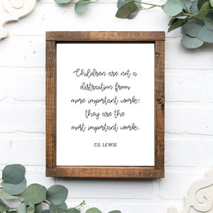 May include: A framed print with a white background and black text that reads "Children are not a distraction from more important work: they are the most important work. C.S. LEWIS".