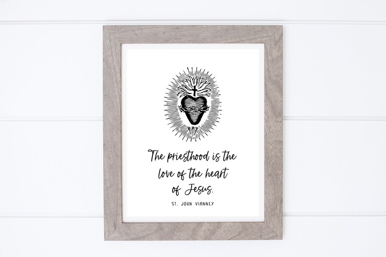 May include: A black and white print with a quote about the priesthood. The quote reads "The priesthood is the love of the heart of Jesus." and is attributed to St. John Vianney. The print features a stylized image of a heart with a crown of thorns and a cross.