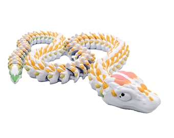 May include: A white segmented snake toy with yellow and green accents. The snake is curled into a figure eight shape and has a detailed head with a pink and white design.