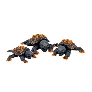 Op de afbeelding: Drie gedetailleerde schildpadbeeldjes. De schildpadden hebben donkergrijze lichamen en oranje en zwart gekleurde schilden. De beeldjes zijn geplaatst op een witte achtergrond, die hun ingewikkelde ontwerp en realistische kenmerken benadrukt.