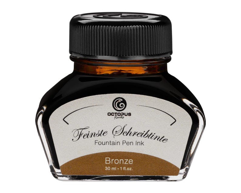 May include: A glass bottle of Octopus Fluids fountain pen ink in Bronze. The bottle has a black cap and a white label with the text "Feinste Schreibtinete Fountain Pen Ink". The bottle contains 30 ml or 1 fl. oz. of ink.