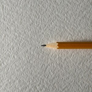 May include: A yellow pencil with a black eraser on a white textured surface.