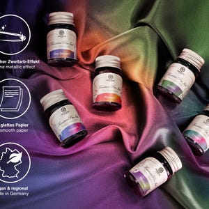 Pu&ograve; includere: Sette piccoli flaconi di vetro di inchiostro per penna stilografica con tappi argentati. I flaconi sono disposti su uno sfondo di tessuto colorato. I colori dell'inchiostro sono Sea Serpent, Phoenix, Unicorn, Goblin, Dragon, Medusa. I flaconi sono etichettati con il testo "Fountain Pen Ink" e il logo del marchio Octopus.