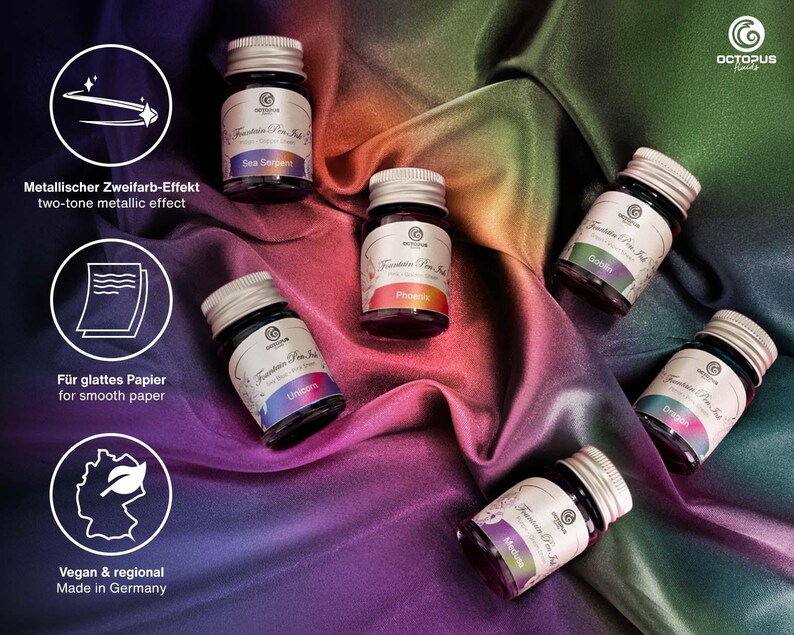 Pu&ograve; includere: Sette piccoli flaconi di vetro di inchiostro per penna stilografica con tappi argentati. I flaconi sono disposti su uno sfondo di tessuto colorato. I colori dell'inchiostro sono Sea Serpent, Phoenix, Unicorn, Goblin, Dragon, Medusa. I flaconi sono etichettati con il testo "Fountain Pen Ink" e il logo del marchio Octopus.