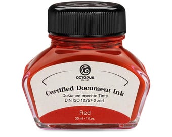 May include: A red ink bottle with a black cap. The label reads "Certified Document Ink" and "Red, 30 ml • 1 fl.oz.". The ink bottle has a unique shape and is filled with vibrant red ink.