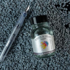 May include: A clear glass bottle with a black cap containing Write & Draw Cleaner, a special cleaner for fountain pens and drawing instruments. The bottle is labeled with a colorful jellyfish illustration and the text "Write & Draw Cleaner" and "Octopus".