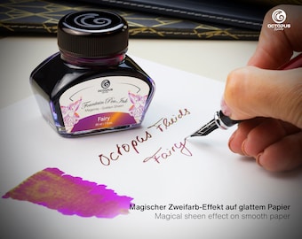 May include: A glass bottle of purple fountain pen ink with a golden sheen. The bottle is labeled "Octopus Fluids Fountain Pen Ink Magenta Golden Sheen Fairy 30 ml - 1 fl. oz.". The ink is being used to write the words "Octopus Fluids Fairy" on a white piece of paper. The ink has a magical sheen effect on smooth paper.
