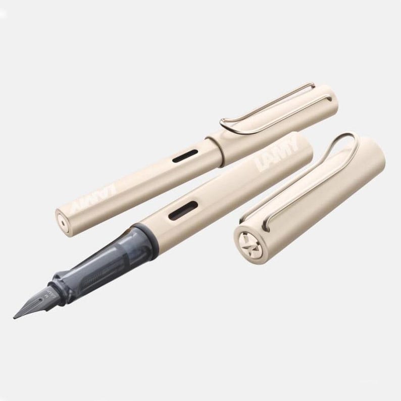 Puede incluir: Un juego de tres plumas estilogr&aacute;ficas Lamy Safari de color dorado claro. Las plumas tienen un clip en la parte superior y un cartucho de tinta negro.