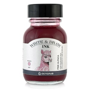 May include: A glass bottle of pink ink with a white label that says "Write & Draw Ink" and features an illustration of a pink alpaca. The label also says "Pink Alpaca" and "For fountain pen, calligraphy nib & brush".