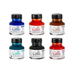 Op de afbeelding: Zes flessen Calli kalligrafie-inkt in diverse kleuren: blauw, rood, bruin, blauwgroen, zwart en een tweede tint rood. Elke fles heeft een zwarte dop en een etiket met de merknaam.