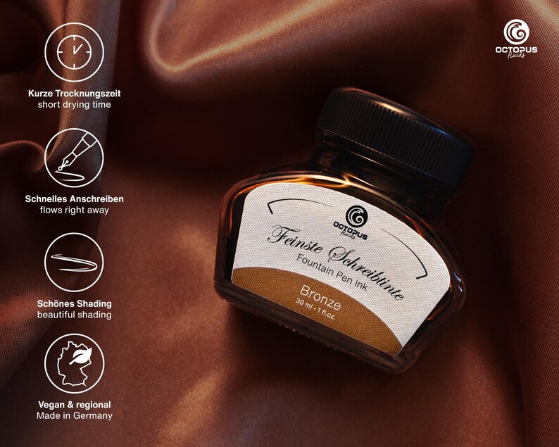 May include: A bottle of bronze fountain pen ink with a black cap. The label reads "Feinste Schreibtinte" and "Bronze". The image also includes text indicating short drying time, quick writing, beautiful shading, and that it is vegan and made in Germany.