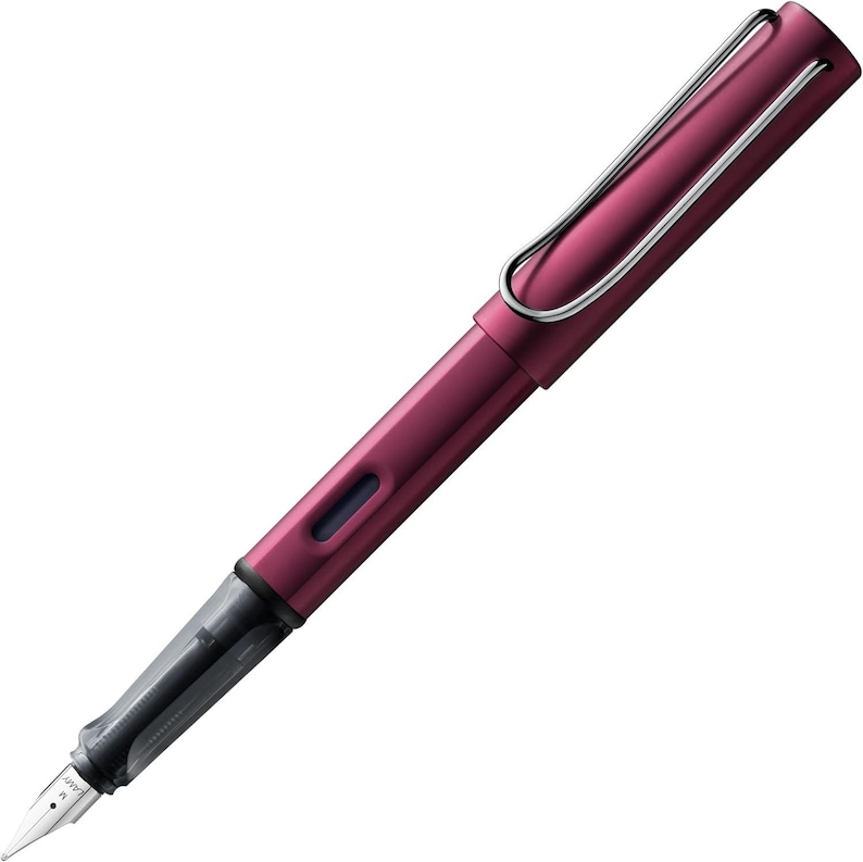 May include: A rose gold fountain pen with a silver clip and a black ink cartridge. The pen has a sleek, modern design.