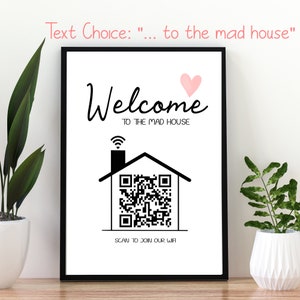 May include: A framed print with the words "Welcome to the Mad House" in black script, a pink heart, and a house graphic with a QR code. The text "Scan to Join Our Wifi" is below the house graphic. The frame is black.