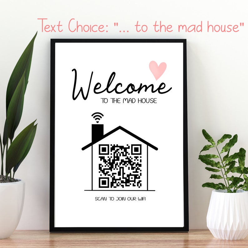 May include: A framed print with the words "Welcome to the Mad House" in black script, a pink heart, and a house graphic with a QR code. The text "Scan to Join Our Wifi" is below the house graphic. The frame is black.