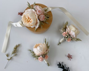 Puede incluir: Tres arreglos florales con flores rosas y melocotón, vegetación y hierbas secas. Los arreglos están sobre un fondo blanco.