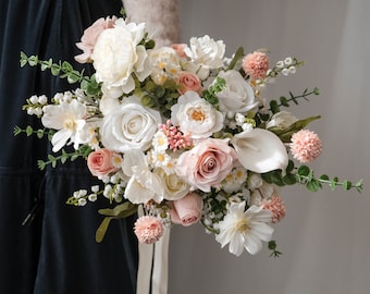 Pode incluir: Um buquê de noiva com rosas brancas e cor-de-rosa, lírios brancos e flores silvestres brancas e cor-de-rosa.