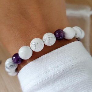 May include: A white and purple beaded bracelet with white howlite and amethyst beads.