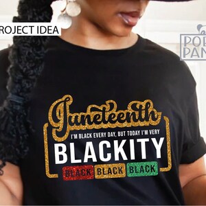 May include: A black t-shirt with gold glitter text that reads "Juneteenth I'm Black Every Day, But Today I'm Very Blackity" with three black squares that say "Black" underneath.