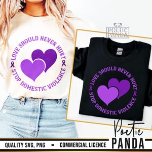 Könnte beinhalten: Zwei schwarze T-Shirts mit einem violetten Kreisdesign. Der Kreis enthält den Text "Liebe sollte niemals weh tun. Stoppt häusliche Gewalt" und ein violettes Band. Im Inneren des Kreises befinden sich zwei violette Herzen.