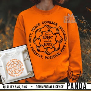 Peut inclure: Sweat-shirt orange vif avec un motif circulaire de mains et le texte "he a BUDDY not a BULLY". Le motif est entouré de mots tels que "Unity, Peace, Courage, Inclusion, Friendly, Positive, Kind". Un petit sweat-shirt blanc est également visible.
