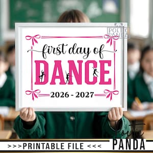 Könnte beinhalten: Ein weiß gerahmtes Schild mit dem Text first day of DANCE in schwarzer und rosa Schrift. Das Design enthält rosa Schleifen an den Ecken und Silhouetten von Tänzern in den Buchstaben. Der Text 2026 - 2027 steht unten auf dem Schild.