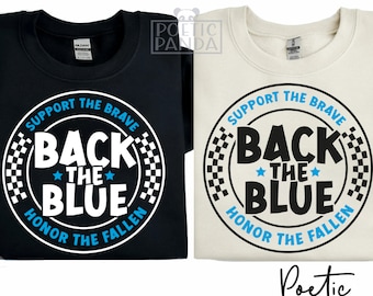 May include: Two t-shirts with a black and white circle design. The circle has the text "Support the Brave Back the Blue Honor the Fallen" in white with a blue "Back the Blue" text. The t-shirts are black and beige.