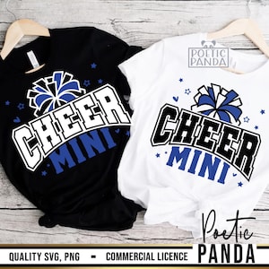 May include: Two t-shirts, one black and one white, with a cheerleading design. The design features the word "CHEER" in a bold, outlined font, and "MINI" in blue. Blue stars and a pom-pom graphic are also included.
