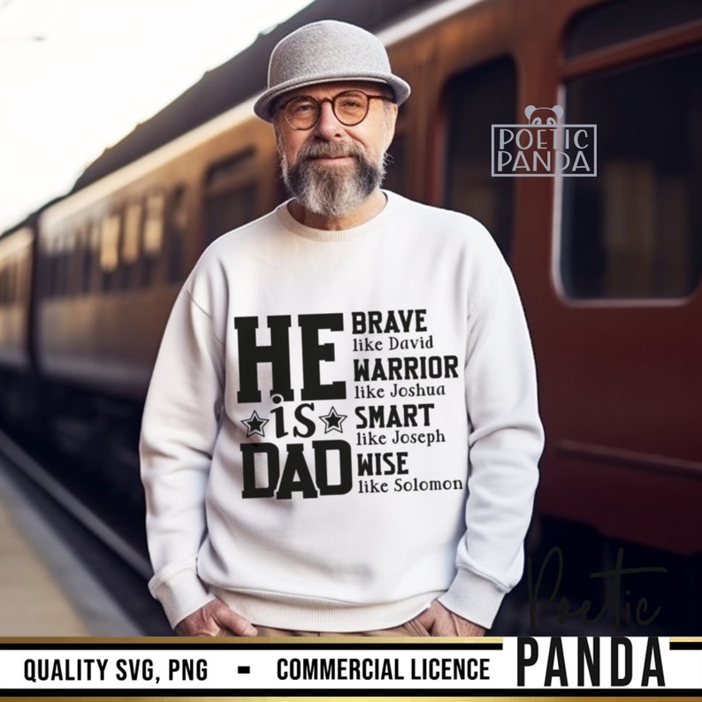 May include: A white sweatshirt with the text "HE IS DAD" in black, with additional text listing qualities like "BRAVE" and "WARRIOR." The sweatshirt is worn by a person wearing glasses and a gray hat.