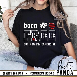 May include: A black t-shirt with the text "born FREE but now I'm expensive" in white. The text is surrounded by a red, white, and blue star-spangled banner design.
