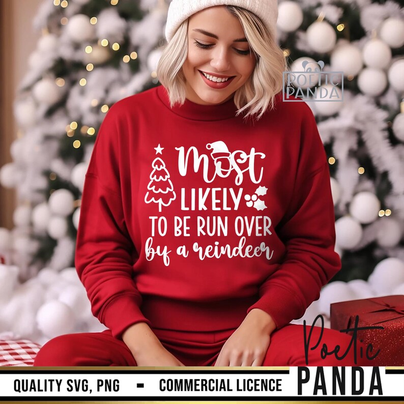 May include: A red sweatshirt with the text "Most Likely To Be Run Over by a Reindeer" in white. The sweatshirt features a Christmas tree and Santa hat graphic. The person is wearing a white beanie and red pants.