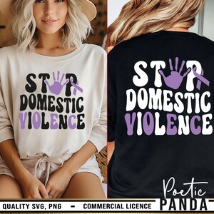 May include: A long-sleeved shirt featuring the text STOP DOMESTIC VIOLENCE in a bold, wavy font. The design includes a purple handprint replacing the letter O and a purple awareness ribbon. The graphic appears in black on a white shirt.