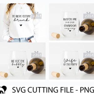 Op de afbeelding: Vier verschillende ontwerpen voor wijnglazen met tekst en een hart. De tekst op de glazen luidt "We got the bubbly", "Wife of the party", "Watch me sip sip chardon nay nay", en "So we're getting drunk". Elk glas staat naast een fles wijn en een kurk.