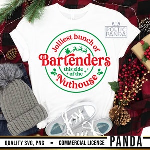 May include: White t-shirt with a festive design. The graphic reads "Jolliest bunch of Bartenders this side of the Nuthouse" in red and green. A gray beanie and canvas sneakers are visible.
