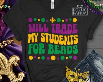 May include: A black t-shirt with the text "WILL TRADE MY STUDENTS FOR BEADS" in purple, yellow, and green lettering. The text is surrounded by a circle of purple, yellow, and green dots. The shirt also has a small fleur-de-lis design above the text.