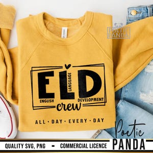 May include: Mustard yellow crewneck sweatshirt with the text "ELD English Language Development crew" in black. The text is inside a black rectangular frame. The phrase "ALL DAY EVERY DAY" is printed below the frame.