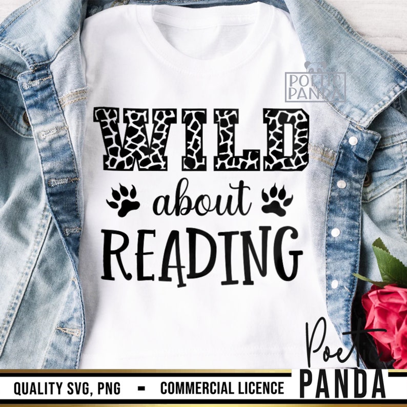 Puede incluir: Camiseta blanca con las palabras "WILD about READING" en letras negras. La palabra "WILD" tiene un estampado de jirafa en blanco y negro. Dos huellas de patas negras est&aacute;n debajo de las palabras "WILD about". La camiseta se muestra sobre una chaqueta vaquera.