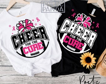 Op de afbeelding: Twee witte en zwarte T-shirts met een roze lint en een cheerleading pompon. De tekst op de shirts luidt "Cheer for the Cure".
