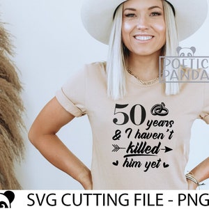 May include: A beige t-shirt with black text that reads "50 years & I haven't killed him yet" with a ring and arrow graphic.