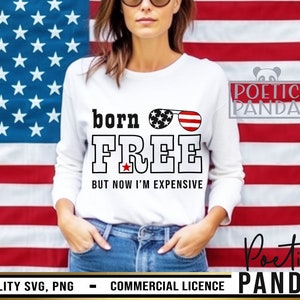 May include: White t-shirt with the text "born FREE BUT NOW I'M EXPENSIVE" in black letters. The text is decorated with a red star and a pair of sunglasses with red, white, and blue stars. The t-shirt is worn by a person standing in front of an American flag.
