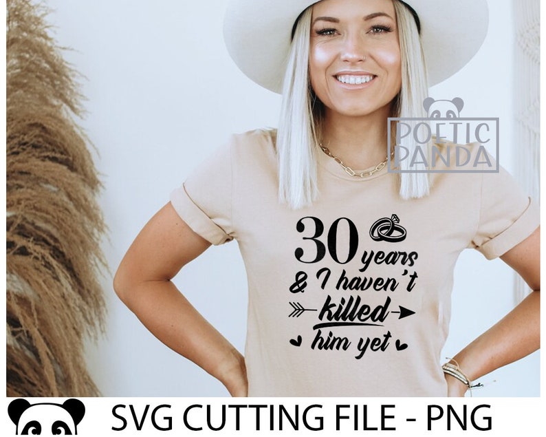 May include: A beige t-shirt with black text that reads "30 years & I haven't killed him yet" with a ring and arrow graphic.